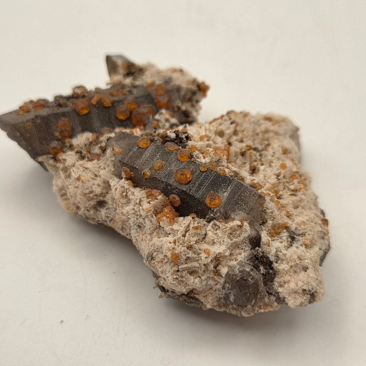 Orange-red spessartine garnet crystals on smoky quartz, natural specimen from Fujian, China