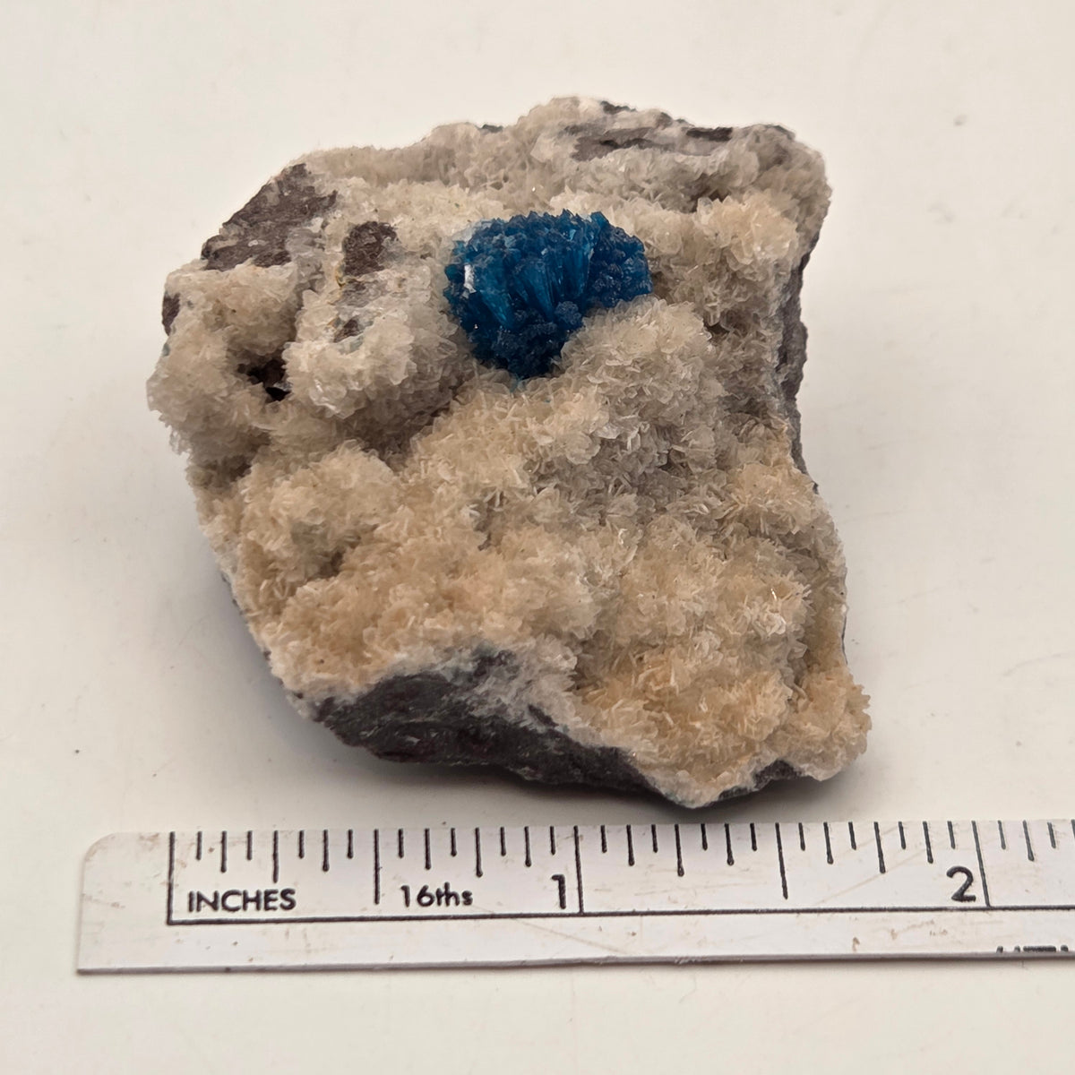 Side view of natural cavansite mineral specimen from India showing vivid blue crystals
