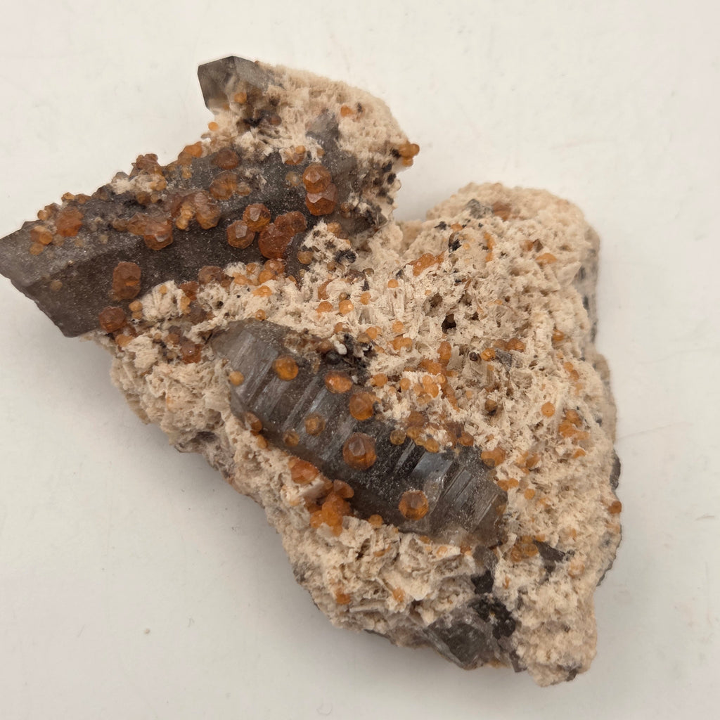 Spessartine garnet on smoky quartz mineral specimen for display